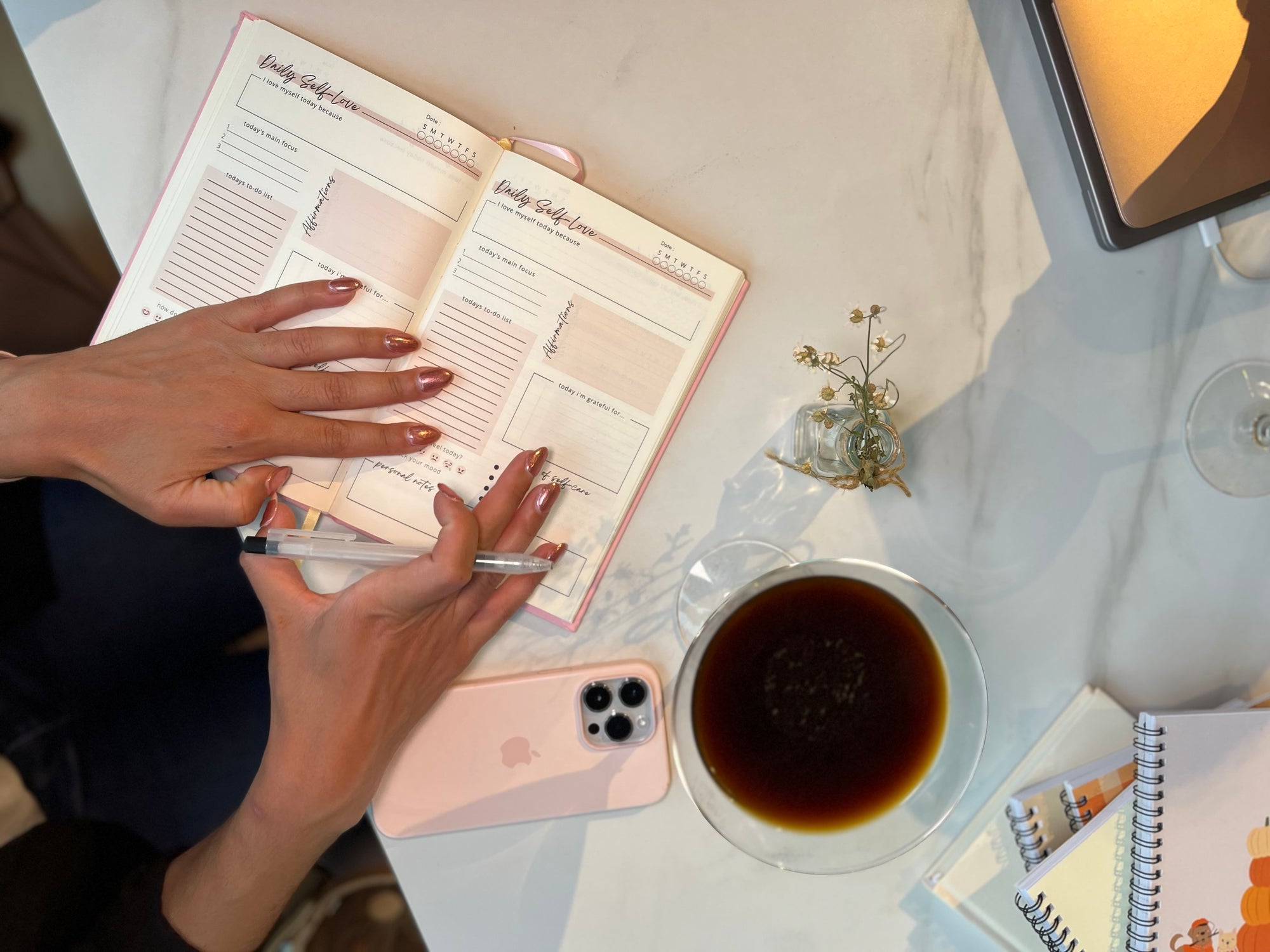Image of manicured nails writing in a journal