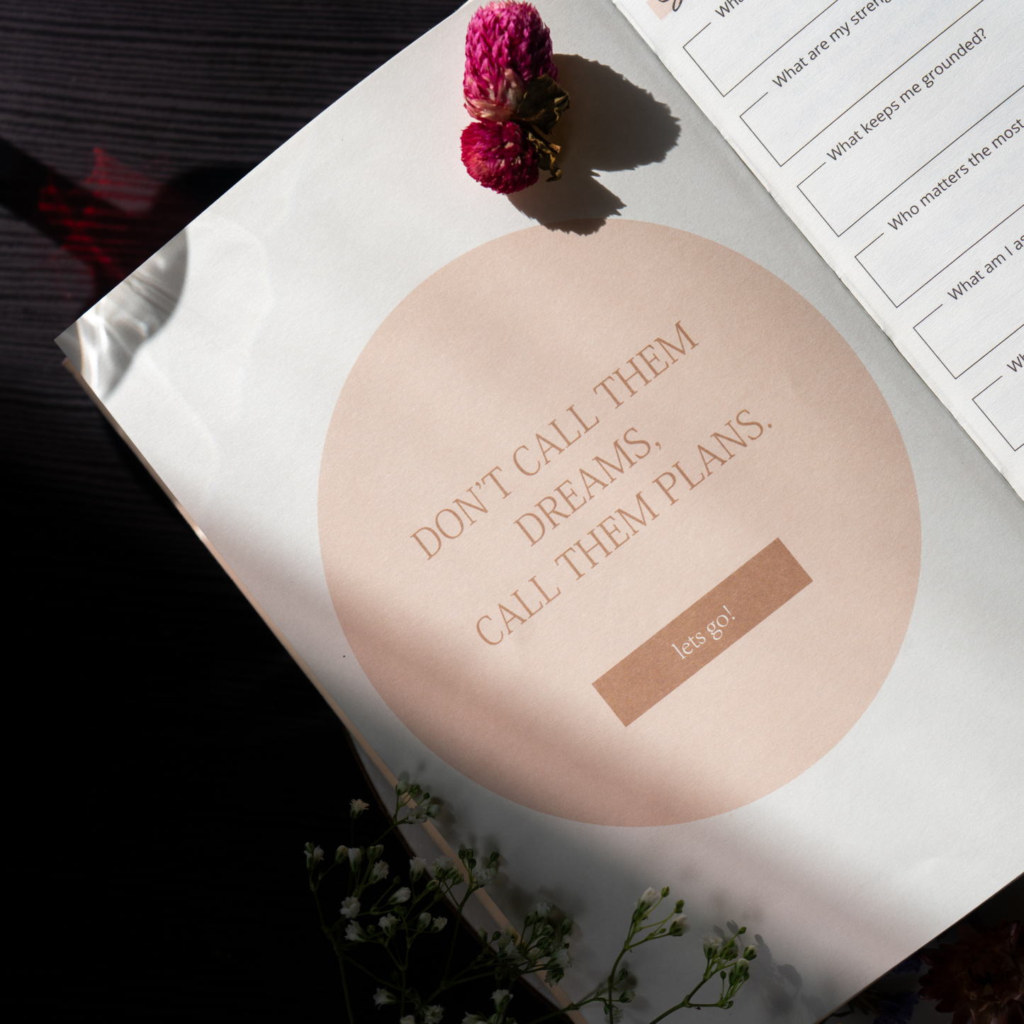 Motivational quote on a pink circular object with flowers and text on a magazine